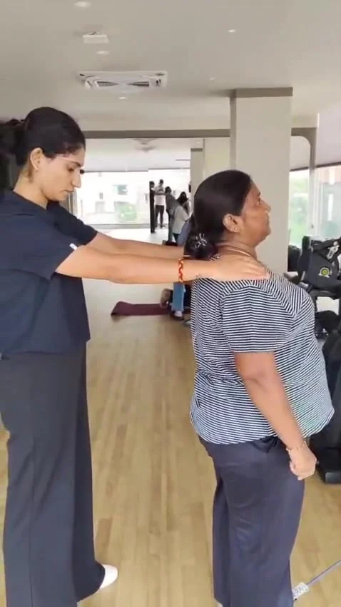Therapist holds a hand on an older woman's shoulder as the woman looks upward