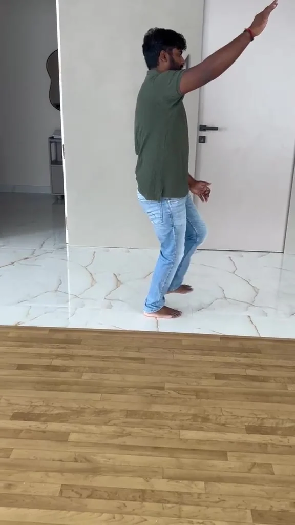 Man in an olive polo raises one arm diagonally toward a white door, his hand cropped at the top of the frame.