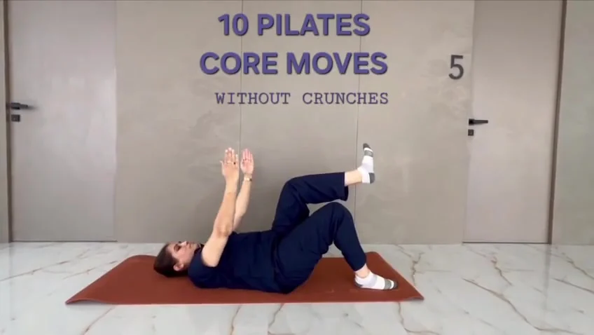 Person lying on an orange mat reaches both arms straight up with one leg raised and bent to tabletop, below a title graphic